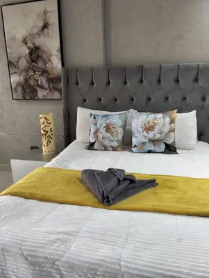 a bed with a towel on top of it at Questro Apartment Hotel in eNyamazaneni