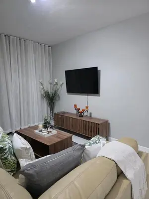 a living room with a couch and a flat screen tv at Menyln 2 Bedroom Apartment in Pretoria