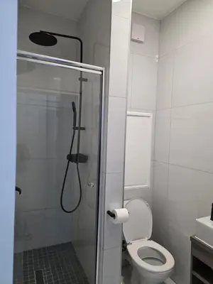 a bathroom with a shower with a toilet and a glass door at Menyln 2 Bedroom Apartment in Pretoria