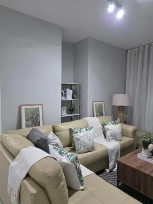 a living room with a couch and a table at Menyln 2 Bedroom Apartment in Pretoria