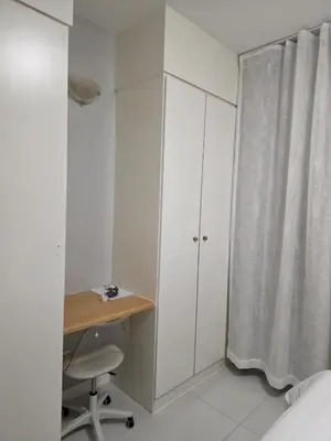 a white bedroom with a desk and a curtain at Menyln 2 Bedroom Apartment in Pretoria