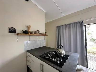 a kitchen with a stove with a tea kettle on it at Palm View in White River