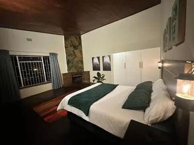 a bedroom with a large bed with two green pillows at Palm View in White River