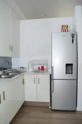 a kitchen with white cabinets and a refrigerator at Luxury Stay at The 28 Pecanwood in Hartbeespoort