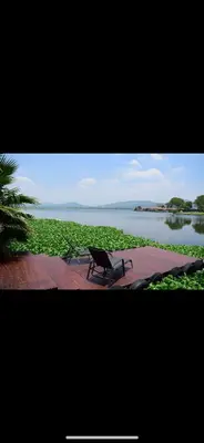 a bench sitting next to a body of water at Luxury Stay at The 28 Pecanwood in Hartbeespoort