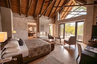 a bedroom with a bed and a desk in a room at Kapama Southern Camp in Kapama Private Game Reserve