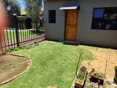 a yard with a fence and a door and grass at Mvuli haven in Pretoria