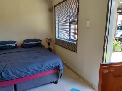 a bedroom with a bed and a window at Mvuli haven in Pretoria