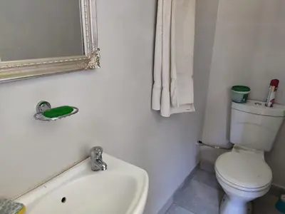 a bathroom with a toilet and a sink and a mirror at Mvuli haven in Pretoria
