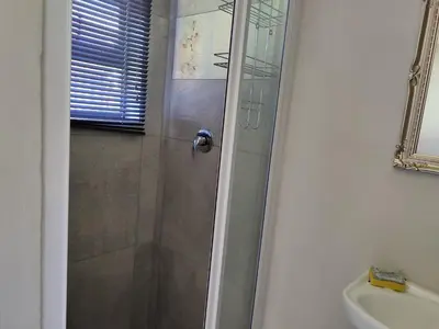 a bathroom with a shower and a sink at Mvuli haven in Pretoria
