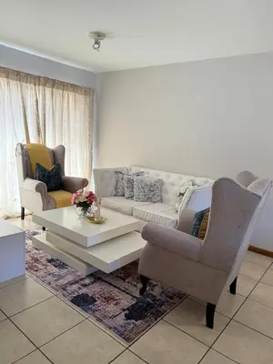 a living room with a couch and a table and chairs at Kloppenheim Sectional Lifestyle Complex in Ellisras