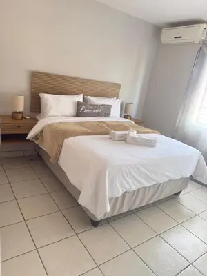 a bedroom with a large bed with two towels on it at Kloppenheim Sectional Lifestyle Complex in Ellisras
