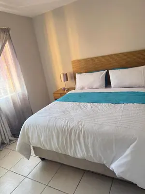 a bedroom with a large bed and a window at Kloppenheim Sectional Lifestyle Complex in Ellisras