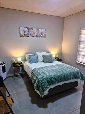 a bedroom with a bed and two tables with lamps at True Star at True North Modern 2 Bed Apartment in Pretoria