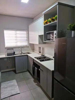 a kitchen with white cabinets and a stove top oven at True Star at True North Modern 2 Bed Apartment in Pretoria