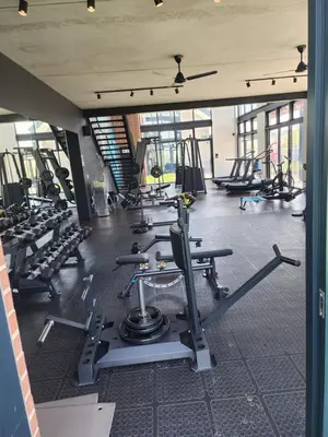 a gym with several rows of treadms and machines at The white house in Midrand