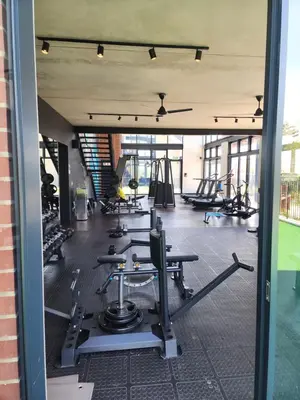 a gym with rows of treadmills and machines at The white house in Midrand