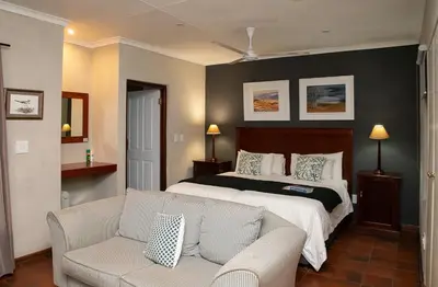 a bedroom with a bed and a couch at Heuglins Lodge in White River