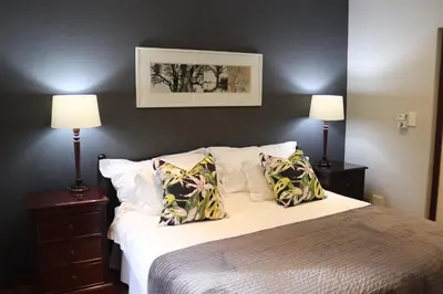 a bedroom with a large bed with two lamps at Heuglins Lodge in White River