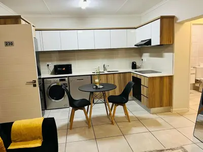a kitchen with a table and chairs in a kitchen at The Luxurious Retreat in Kyalami in Midrand