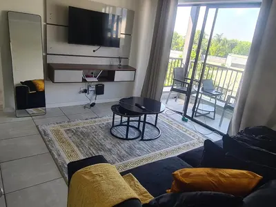 a living room with a couch and a flat screen tv at The Luxurious Retreat in Kyalami in Midrand
