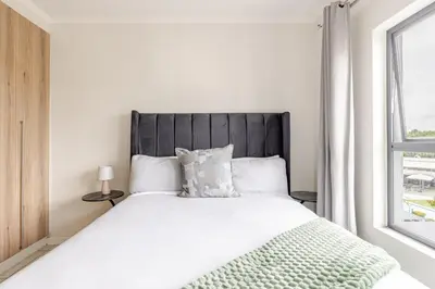 a bedroom with a large white bed with a window at The Luxurious Retreat in Kyalami in Midrand