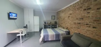 a bedroom with a bed and a brick wall at 329 on 30th Avenue Villieria Aimee in Pretoria