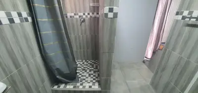 a shower with a black and white checkered floor at 329 on 30th Avenue Villieria Aimee in Pretoria