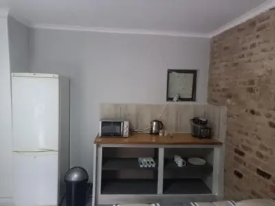 a kitchen with a table with a microwave and a refrigerator at 329 on 30th Avenue Villieria Aimee in Pretoria