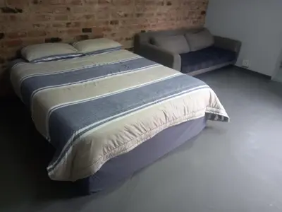 a bed and a couch in a bedroom at 329 on 30th Avenue Villieria Aimee in Pretoria
