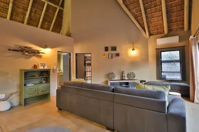 a large living room with couches and a kitchen at Lodana -next to Crocodile River in Marloth Park