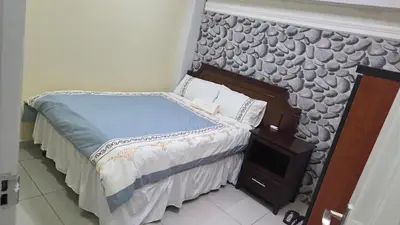 a small bedroom with a bed with a wall at ntaleguesthouse in Benoni