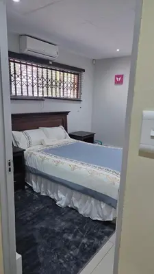 a bedroom with a large bed with a window at ntaleguesthouse in Benoni