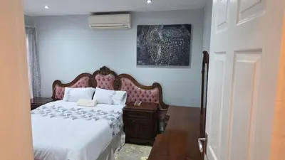 a bedroom with a bed and a wooden nightstand at ntaleguesthouse in Benoni