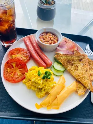 a plate of breakfast food with eggs sausage beans and toast at Pebetse Guesthouse in Acornhoek