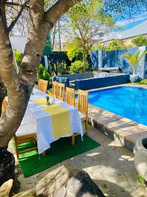 a table and chairs next to a swimming pool at Pebetse Guesthouse in Acornhoek
