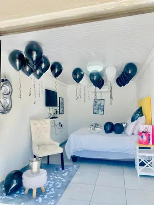 a room with blue balloons and a bed and a chair at Pebetse Guesthouse in Acornhoek