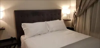 a bedroom with a bed with white sheets and pillows at Peaceful Casa in Kempton Park