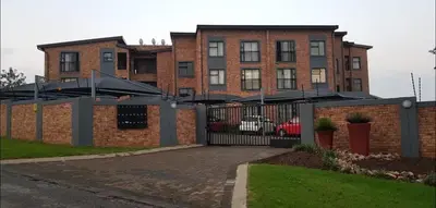 a building with a black gate and a building at Peaceful Casa in Kempton Park