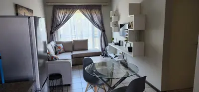 a living room with a glass table and a couch at Peaceful Casa in Kempton Park