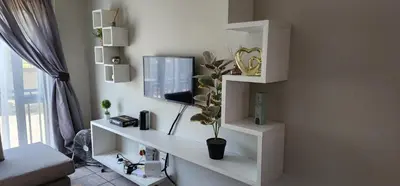 a living room with white shelves and a tv at Peaceful Casa in Kempton Park