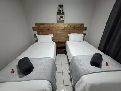 two beds in a small room with towels on them at Stay-on-Skalie in Nelspruit