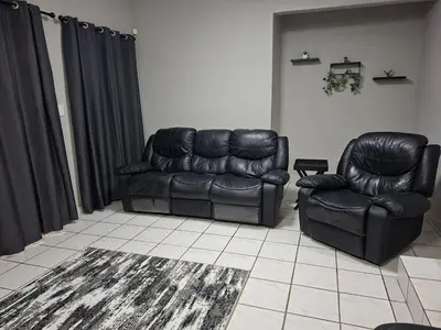 a living room with a leather couch and a chair at Stay-on-Skalie in Nelspruit