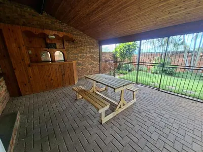 a wooden bench sitting on a patio with a large window at Stay-on-Skalie in Nelspruit