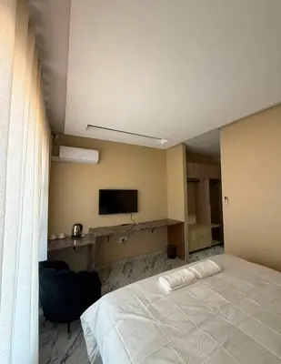 a bedroom with a white bed and a television at dream club in Thohoyandou