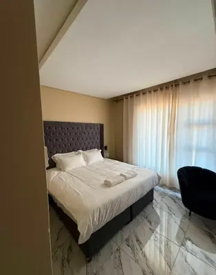 a bedroom with a large bed and a window at dream club in Thohoyandou