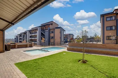 a small tree in a yard in front of a building at Home Away By Waterfall in Midrand