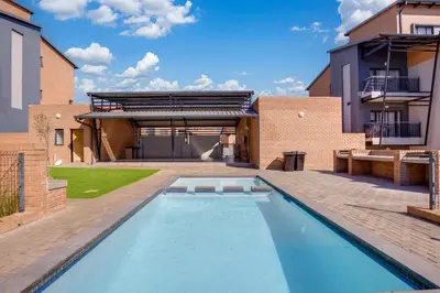 a swimming pool in the backyard of a house at Home Away By Waterfall in Midrand