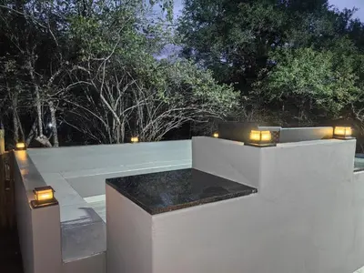 a patio with a bench with lights on it at Eagle's Retreat in Marloth Park