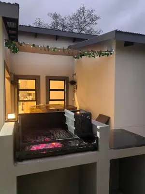 a balcony of a house with a grill at Eagle's Retreat in Marloth Park